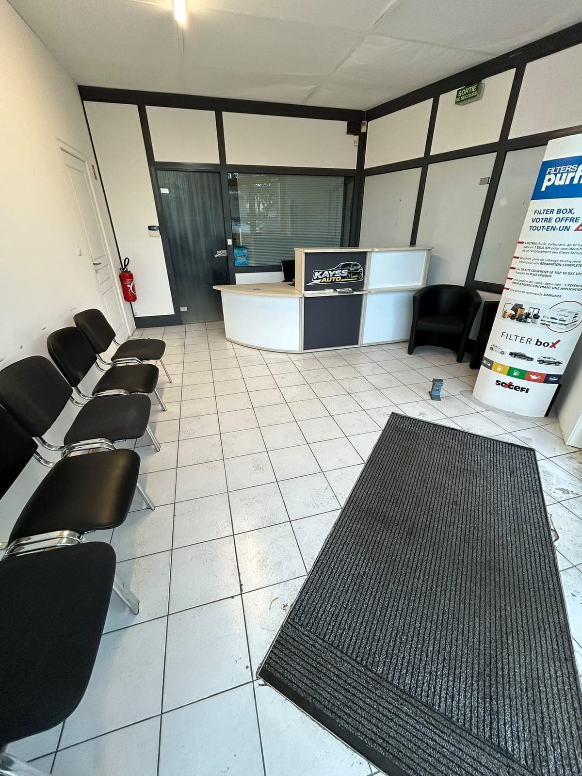 Salle d'attente avec chaises, fauteuils et comptoir d'accueil Kayss Auto.
